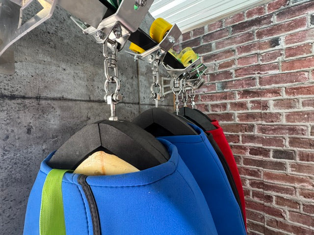 Surfboards stored in Radd Raxx neoprene girdles hanging on a wall-mounted slide track
