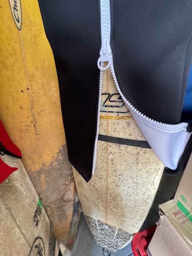 Lift leash attached to the surfboard, girdle partially zipped tight.